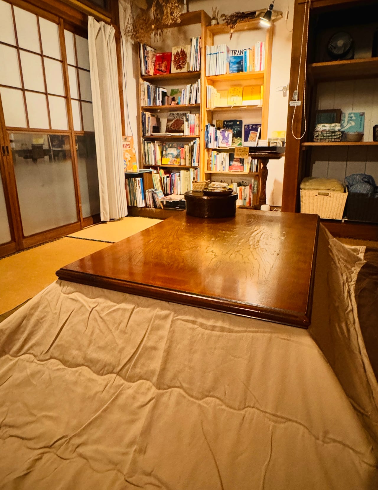 NEMARU’s quilt-covered kotatsu table in a tatami room with bookshelves